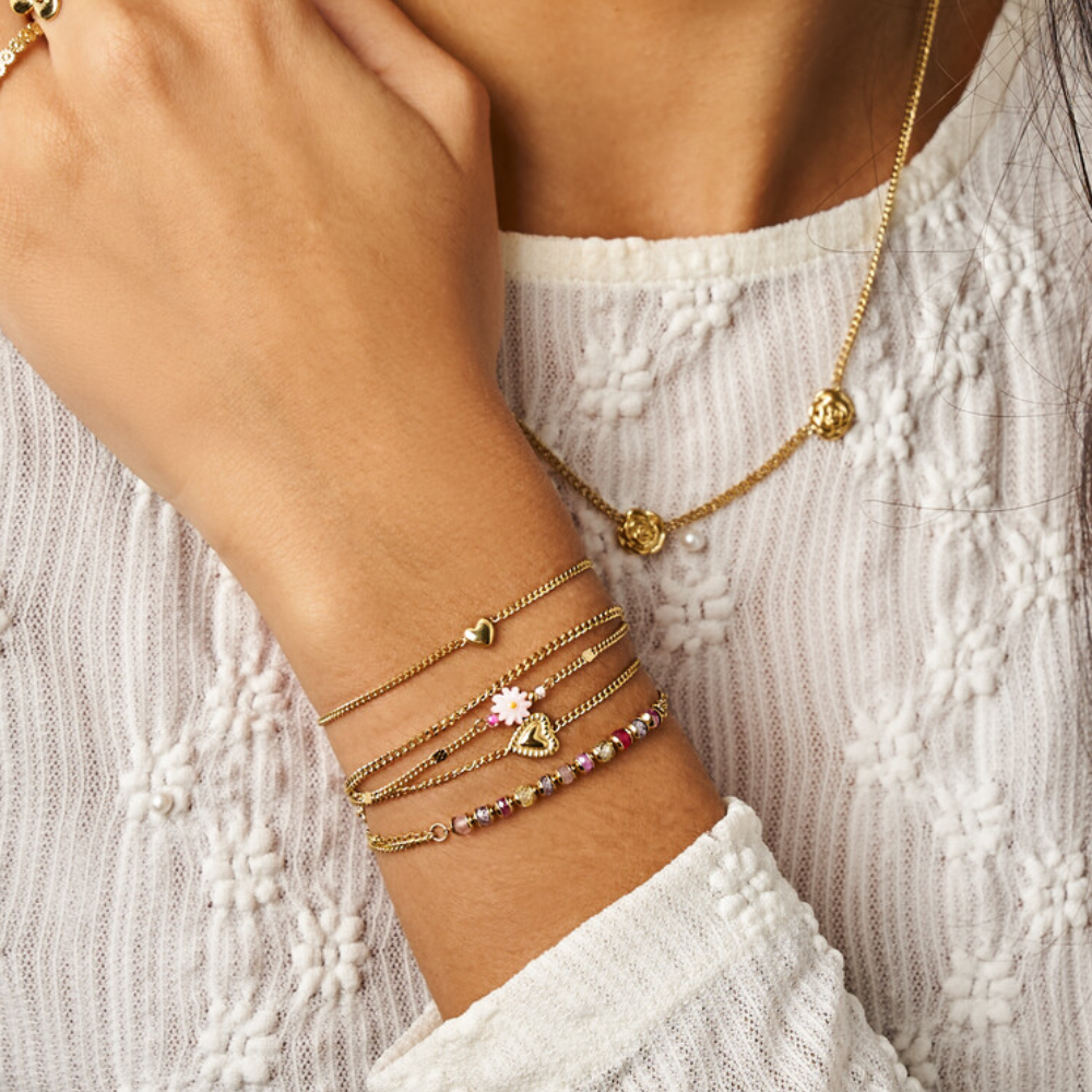 Guld armbånd med ét hjerte vist på model sammen med flere armbånd fra My Jewellery