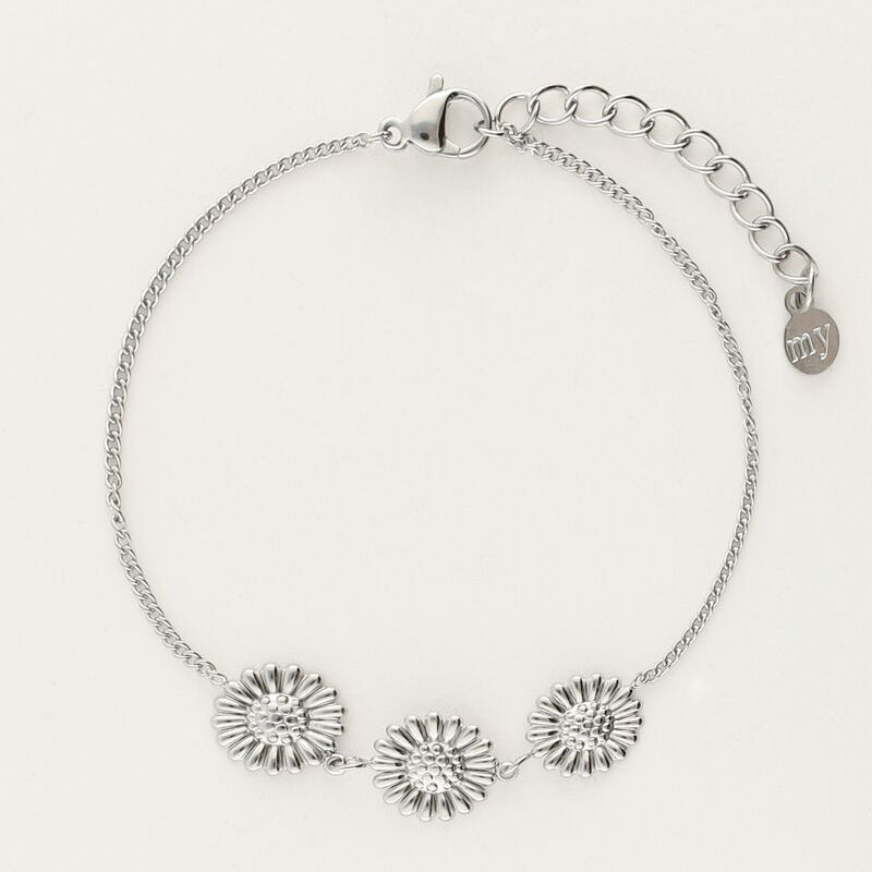Sølvfarvet armbånd med tre solsikke-charms på fin kæde, fotograferet som produktbillede på lys baggrund