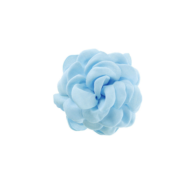 By Stær Daisy hårklemme i pastel blå med stor stofblomst og sort klemme.
