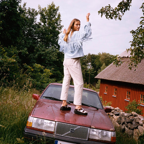 Model set bagfra iført Sissel Edelbo Christer Jakke i lys denim med lange frynser langs ryggen og ærmerne
