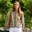 Model iført Sissel Edelbo Como Jakke i sand med blåmønstrede kanter og store frontlommer