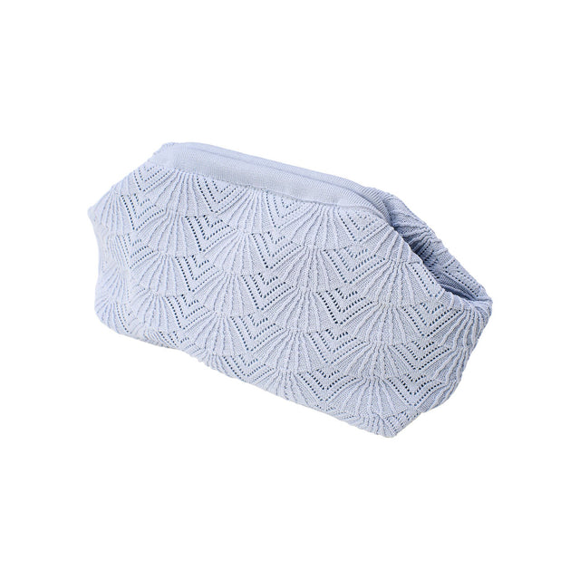 Lyseblå Shelly clutch fra Pico Copenhagen med flettet mønster inspireret af skaldyr på hvid baggrund.
