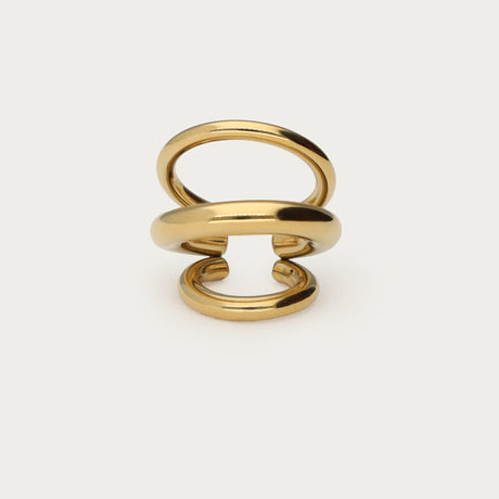 Guldfarvet earcuff med tre rækker, fotograferet som produktbillede på lys baggrund