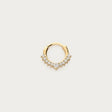 Guldfarvet daith-piercing med skarpt design og strass, fotograferet som produktbillede på lys baggrund