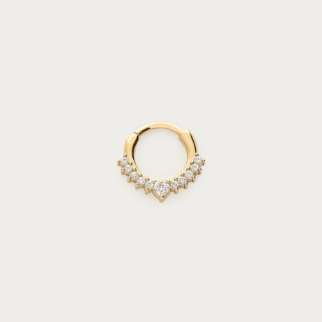 Guldfarvet daith-piercing med skarpt design og strass, fotograferet som produktbillede på lys baggrund