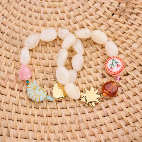Stylet opstilling med flere guldfarvede armbånd og farverige resin-charms