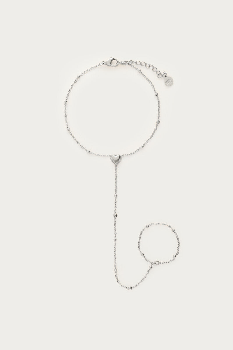 Sølvfarvet handchain-armbånd med hjertevedhæng, fotograferet som produktbillede på lys baggrund