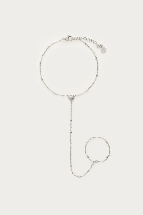 Sølvfarvet handchain-armbånd med hjertevedhæng, fotograferet som produktbillede på lys baggrund