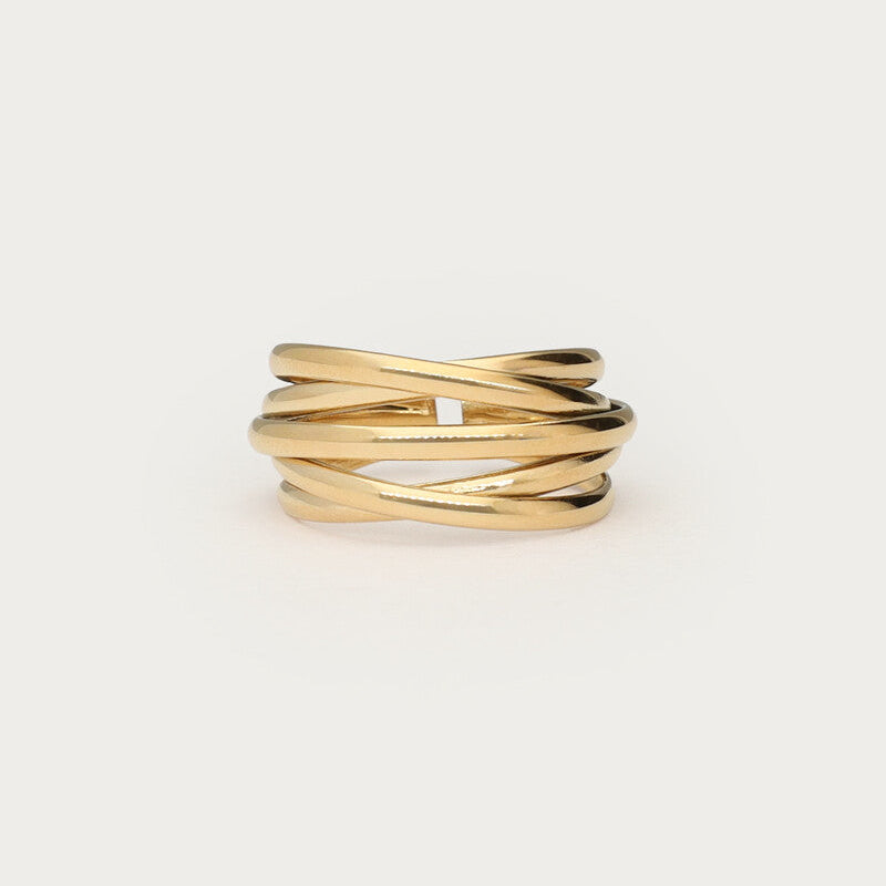 Guldfarvet justerbar ring i wire-design med krydsede tråde, fotograferet som produktbillede på lys baggrund