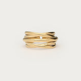 Guldfarvet justerbar ring i wire-design med krydsede tråde, fotograferet som produktbillede på lys baggrund